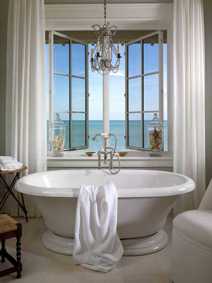 The bathroom has a beautiful view of the sea